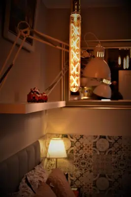 a room with a lamp and a table with a light at Cracovia Garden Nowa 5 Dzielnica in Kraków