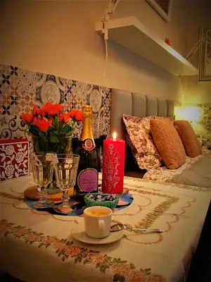 a table with a candle and a bottle of champagne at Cracovia Garden Nowa 5 Dzielnica in Kraków