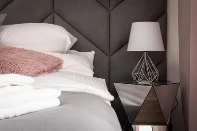 a bedroom with a bed with a lamp on a night stand at Crystal Luxury Apartments Rakowicka 20H in Kraków