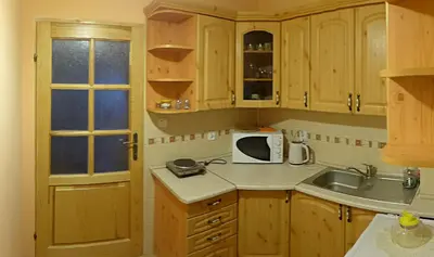 a kitchen with wooden cabinets and a sink and a microwave at Willa Modrysówka in Zawoja