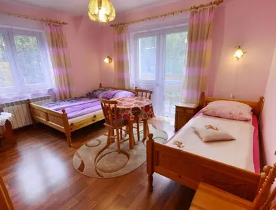 a bedroom with two beds and a table and chairs at Willa Modrysówka in Zawoja