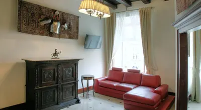a living room with a red couch and a window at Only Kraków Apartments in Kraków