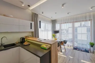 a kitchen with a sink and a table with a desk at atHome Suites in Kraków