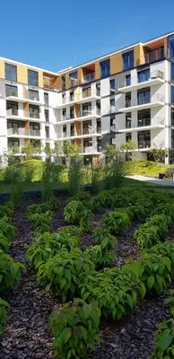 a large apartment building with a garden of plants at atHome Suites in Kraków