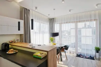 a kitchen with a table and a large window at atHome Suites in Kraków