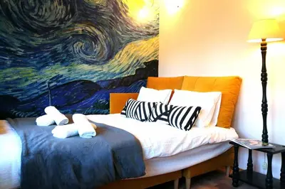 a bedroom with a bed with a painting on the wall at Koci Dom in Wieliczka