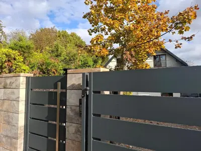 a black fence with a gate in front of a house at Koci Dom in Wieliczka