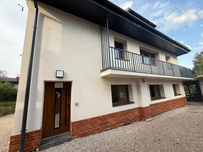 a white building with a balcony and a door at Koci Dom in Wieliczka