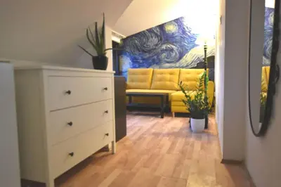 a living room with a white dresser and a yellow couch at Koci Dom in Wieliczka