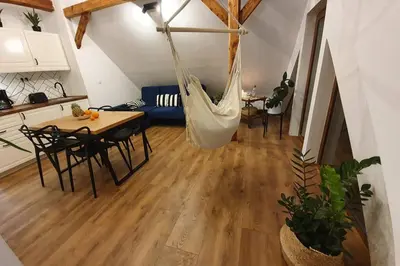 a living room with a hammock in the middle of a room at Koci Dom Loft in Wieliczka