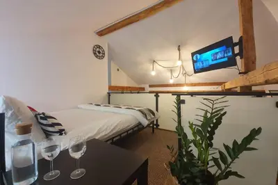 a bedroom with a bed and a table with wine glasses at Koci Dom Loft in Wieliczka