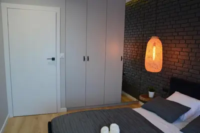 a bedroom with a bed and a brick wall at Last Floor Apartment - Krakow City Center close to Old Town in Kraków
