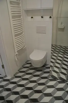 a bathroom with a toilet and a black and white floor at Last Floor Apartment - Krakow City Center close to Old Town in Kraków