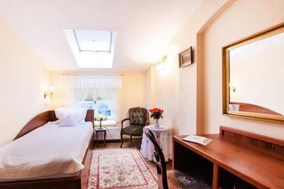 a bedroom with a bed and a desk and a mirror at Aparthotel Grodzka 21 Self-Check in in Kraków
