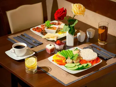 a table with two plates of food and a cup of coffee at Aparthotel Grodzka 21 Self-Check in in Kraków