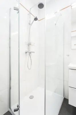 a shower with a glass door in a bathroom at City of the Kings - Leaf Apartment in Kraków