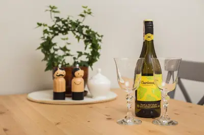 a bottle of wine sitting on a table with two glasses at City of the Kings - Leaf Apartment in Kraków