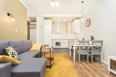 a living room and kitchen with a couch and a table at City of the Kings - Leaf Apartment in Kraków