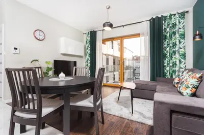 a living room with a table and a couch at City of the Kings - Leaf Apartment in Kraków