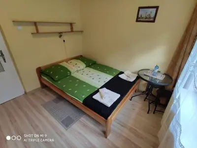 a small bedroom with a bed and a table at Apartament-studio, pokoje u Lucy in Rabka