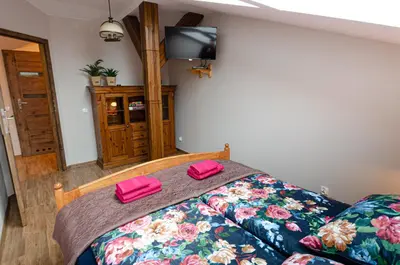 a bedroom with a bed with two pink slippers on it at Bronowicka Premium Apartment - 52m2 with private parking in Kraków