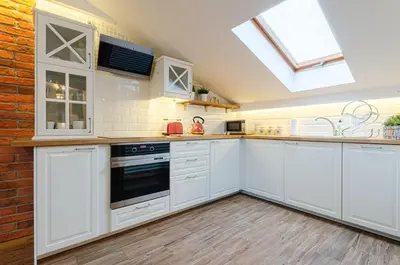 a kitchen with white cabinets and a skylight at Bronowicka Premium Apartment - 52m2 with private parking in Kraków