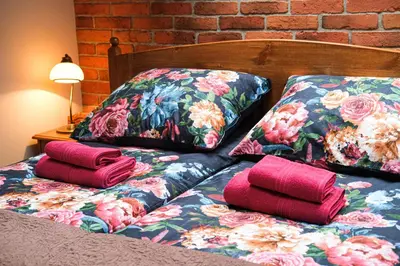 two pillows on a bed next to a brick wall at Bronowicka Premium Apartment - 52m2 with private parking in Kraków
