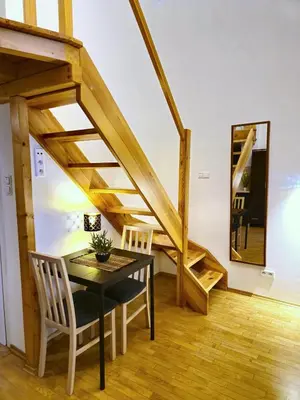 a dining room with a table and a staircase at Safona - Pantheon Apartments in Kraków