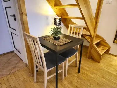 a dining room with a black table and chairs at Safona - Pantheon Apartments in Kraków