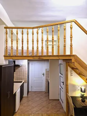 a wooden staircase in a kitchen with a table at Safona - Pantheon Apartments in Kraków