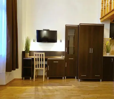 a room with a desk and a tv on a wall at Safona - Pantheon Apartments in Kraków