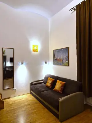a living room with a couch and a mirror at Safona - Pantheon Apartments in Kraków
