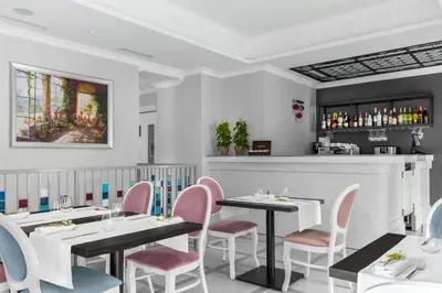 a restaurant with two tables and chairs and a bar at Merci Boutique Hotel in Kraków