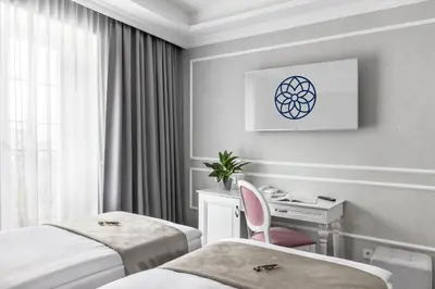 a hotel room with two beds and a desk at Merci Boutique Hotel in Kraków