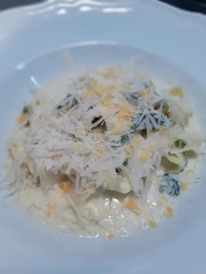 a plate of food with noodles and cheese at Merci Boutique Hotel in Kraków
