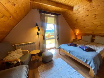 a attic room with two beds and a couch at Babie Domki in Zawoja