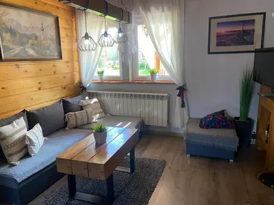 a living room with a couch and a coffee table at Babie Domki in Zawoja