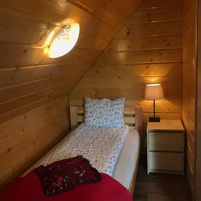 a bedroom with a bed in a wooden cabin at Babie Domki in Zawoja