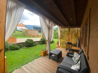 a screened in porch with a couch and a chair at Babie Domki in Zawoja