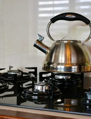 a tea kettle sitting on top of a stove at Siedlisko Inwałd in Inwałd