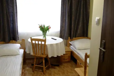 a small room with a table with a vase of flowers on it at Hostel Rest in Kraków