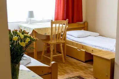a room with two beds and a table and a chair at Hostel Rest in Kraków
