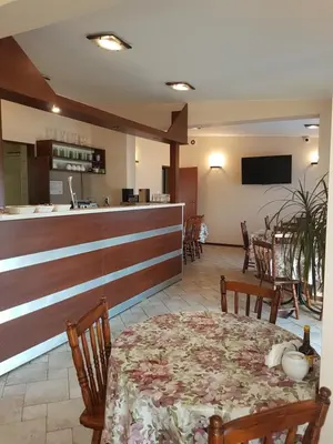 a dining room with a table and a bar at Hostel Rest in Kraków