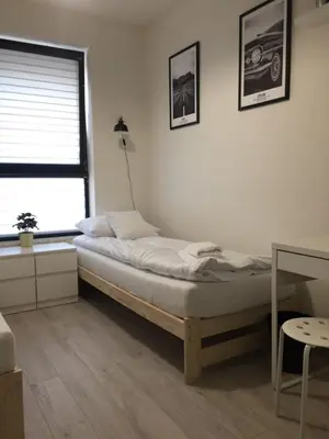 a bedroom with a bed and a window and a desk at Apartament Kraków Arena No 76 in Kraków