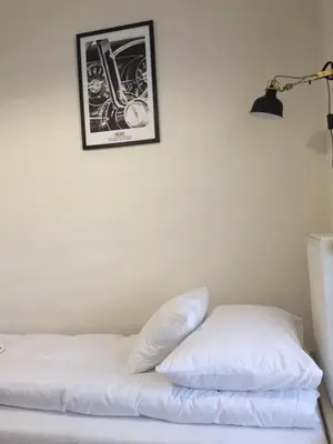 a bed with white sheets and a picture on the wall at Apartament Kraków Arena No 76 in Kraków