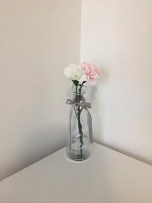 a vase filled with pink and white flowers on a shelf at Apartament Kraków Arena No 76 in Kraków