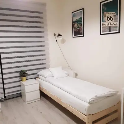 a white bedroom with a bed and a lamp at Apartament Kraków Arena No 76 in Kraków