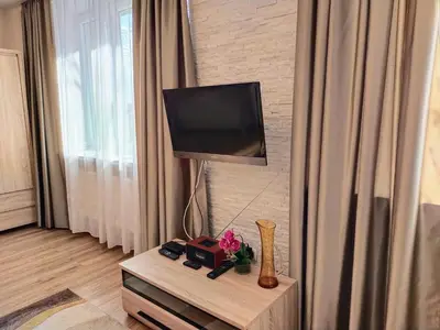 a living room with a television on a wall at Piast Apartament in Kraków