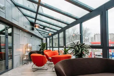 a lobby with orange chairs and windows at Krowodrza Centrum Konferencyjno - Hotelowe in Kraków