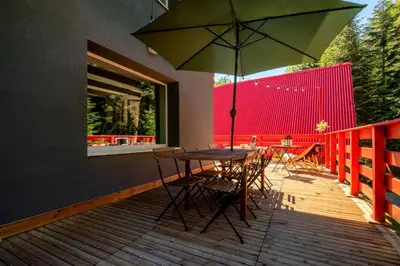 a table and chairs with an umbrella on a deck at Zawoja 1725 - Slow Life Cabins in Zawoja